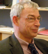 Portrait eines Mannes mit grauem Haar und randloser Brille, er tr�gt ein gestreiftes Hemd und Krawatte